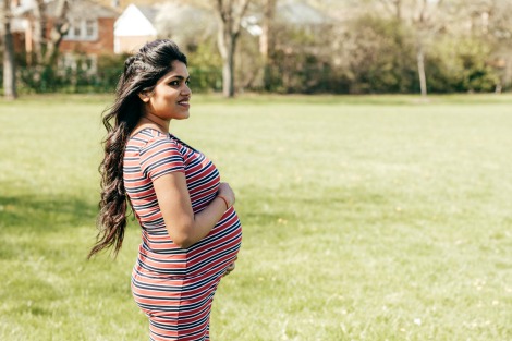 Pregnant woman cradles belly