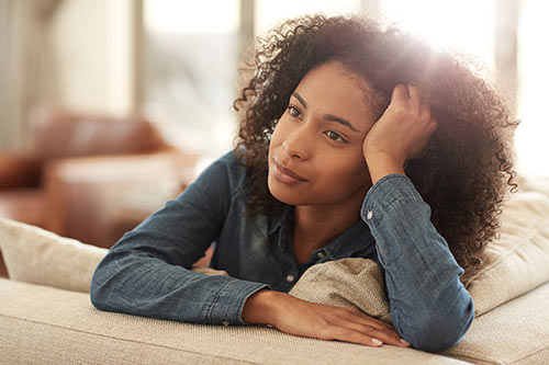 Woman thinking about birth parents and adoption rights from her living room