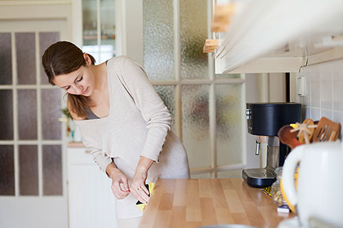 Young woman cleaning her kitchen counters getting ready to prepare favorite recipe