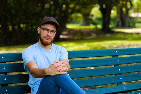 a birth father sitting on park bench wondering about his rights in adoption