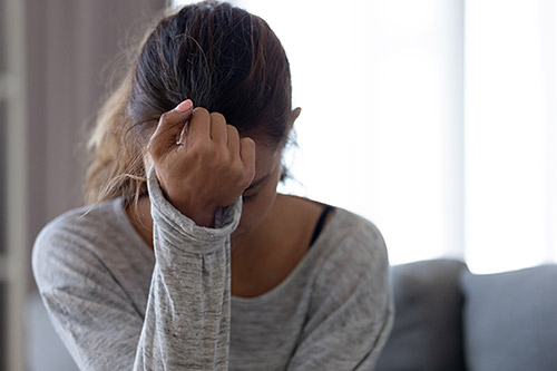 Young woman crying in her living room, wondering how she will heal post-adoption