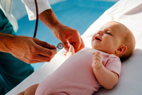 Pediatrician examining an adopted baby girl