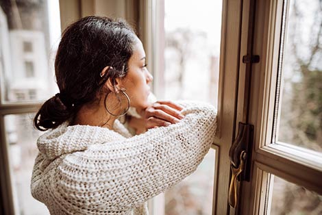 Woman thinks about her unplanned pregnancy as she looks out the window