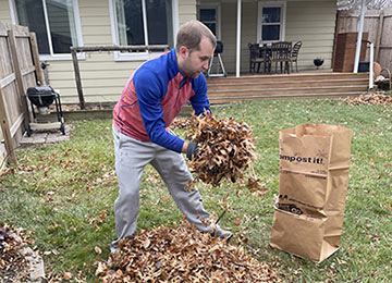 Nick working on bagging leaves he raked in their yard