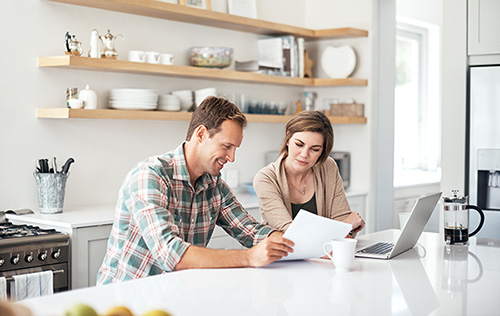 Married couple seated in their kitchen to work on home study paperwork